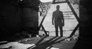 একটি কালো ও সাদা ছবি যেখানে একজন পুরুষের প্রতিকৃতি (silhouette) এবং তার দীর্ঘ, নাটকীয় ছায়া একটি ফাটা, রোদ-ঝলমলে পাথরের দেওয়ালে পড়েছে। দেওয়ালে লেখা ইংরেজি উক্তিটি "EVEN SHADOWS HOLD THEIR TRUTH, UNSEEN ONLY WHEN LIGHT PREVAILS" দিয়ে মূল বাংলা দার্শনিক লেখাটিকে ("ছায়ারও নিজস্ব সত্য আছে, শুধু আলো বেশি পেলে– ওটা দেখা যায় না") তুলে ধরা হয়েছে। কিওয়ার্ড: ছায়া, সত্য, দর্শন, বাংলা উক্তি, আলোর প্রভাব।